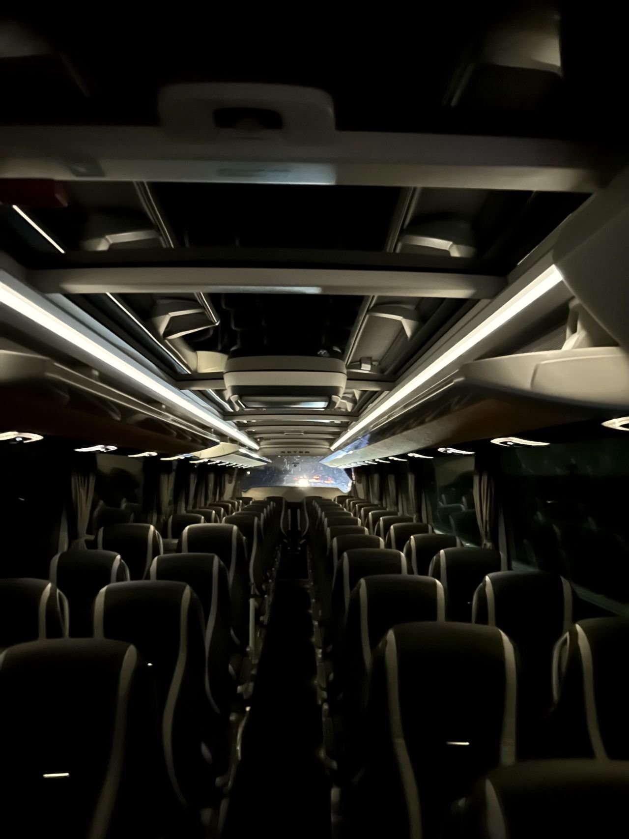 Rows of seats either side of the aisle inside a touring coach